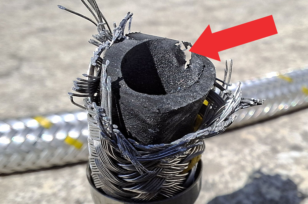 Pohľad na prasknutú časť starej plynovej hadice po rozrezaní hadice